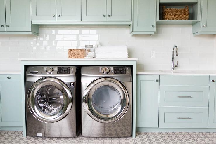Green laundry room with stainless steel washing machines