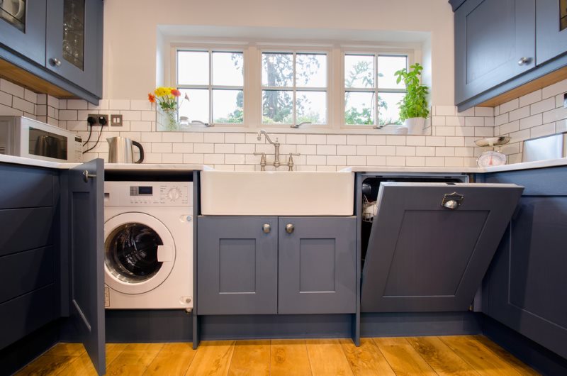 Стиральная машинка за серыми фасадами кухонного гарнитура