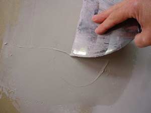 photo skimming a second coat of joint compound off a patch