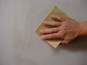 photo of hand sanding a wall patch