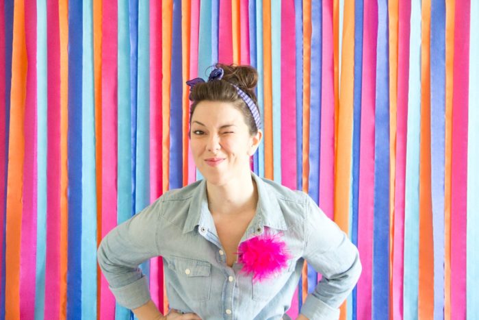 A female model in front of a colorful photoshoot backdrop
