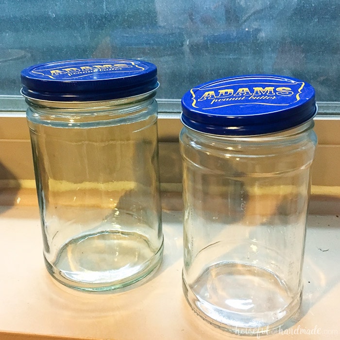 set of two glass peanut butter jars with blue lids.