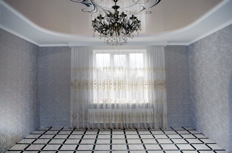 Classic empty interior with a light wall, stone tiles on the floor, window and curtain, decor, ceiling, skirting and a large. Beautiful chandelier stock photos Classic empty interior with a light wall, stone tiles on the floor, window and curtain, decor, ceiling, skirting and a large. Beautiful chandelier stock photos