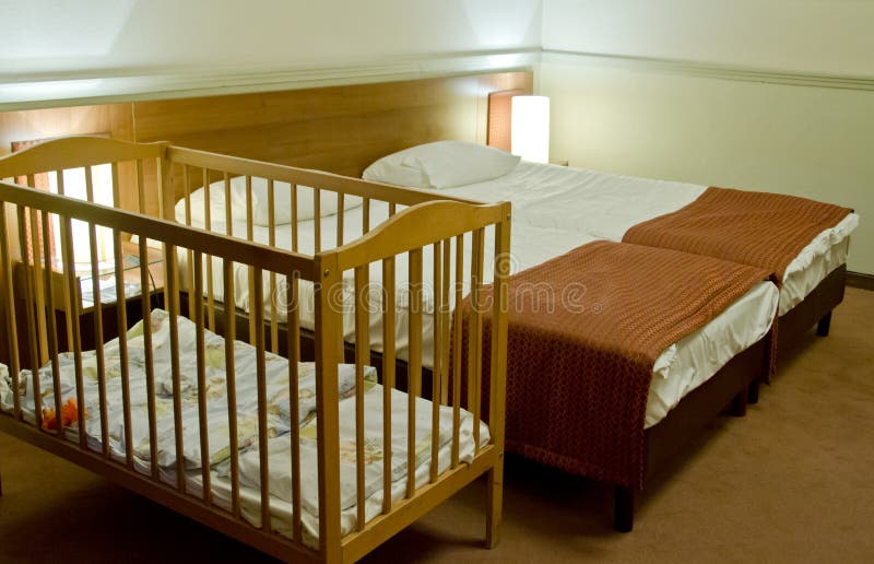 Double bed room with baby cot stock photography