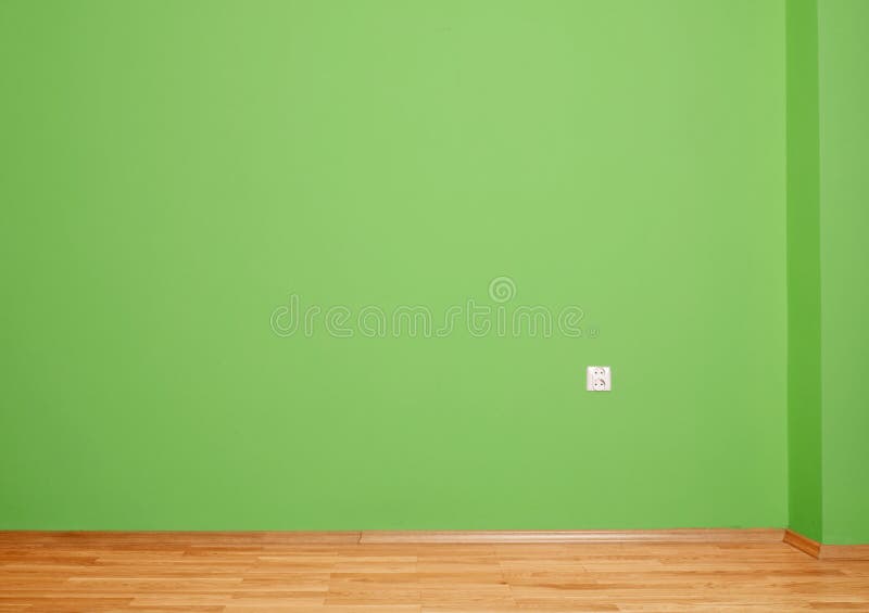 Interior room with wooden floor and wall in green with an electrical contact in the wall and wooden skirting. Interior room with wooden floor and wall in green stock images