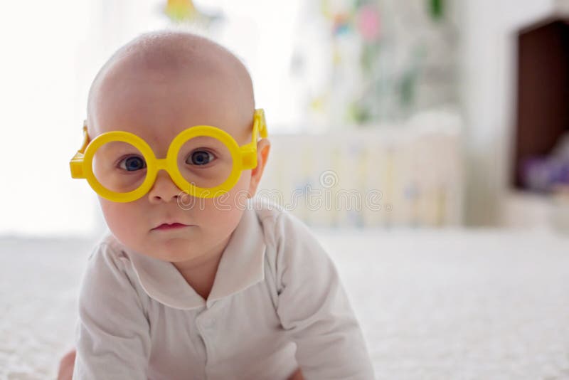 Little baby boy, toddler, playing at home with funny eye glasses royalty free stock images