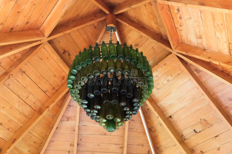 Old Bottle Chandelier. A chandelier made from old bottles in green and blue hang from the inside of a wooden gazebo royalty free stock photos