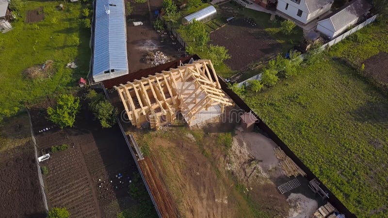 Plot with construction of wooden house. Clip. Top view on frame of wooden house on private country plot in summer. Frame. Of wooden house in process of royalty free stock image