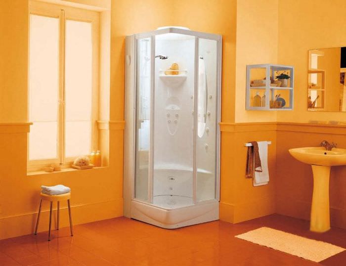 Маленькая ванная комната в оранжевом цвете с угловой душевой кабиной 