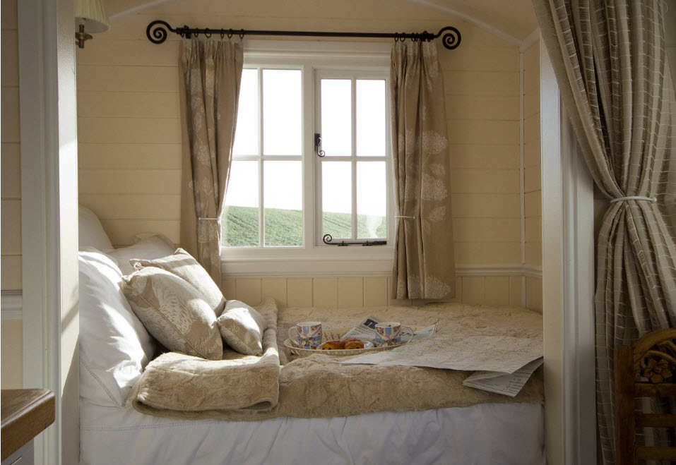 Небольшая кровать у окна за шторой