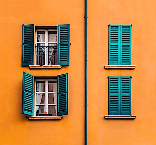 Louvered shutters are a perfect fit for the casement windows of this home