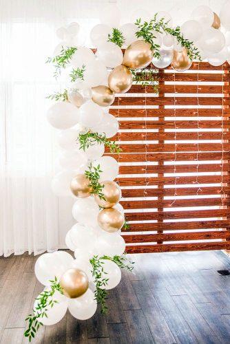 wedding balloon decorations wooden palettes backdrop and gold white balloon garland paperandparties