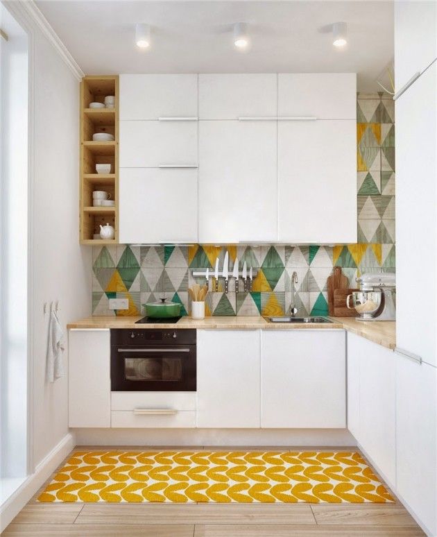 Небольшая белая кухня с яркими геометрическими фигурами на полу и стене